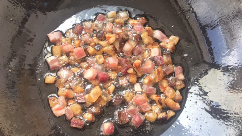 土豆腊肉焖饭,肥油提炼出来后,瘦腊肉一起倒入锅中翻炒片刻。