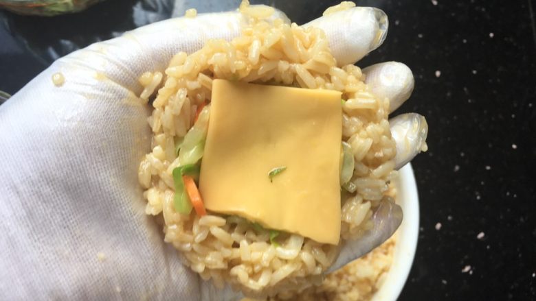芝士肉松饭团,戴手套,米饭里面包蔬菜和芝士,整成球形