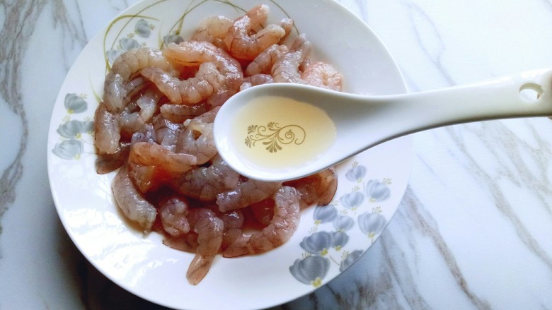 #东南亚风味的#椰汁咖喱虾,洗干净的虾仁放入盘子中,加入一勺料酒。