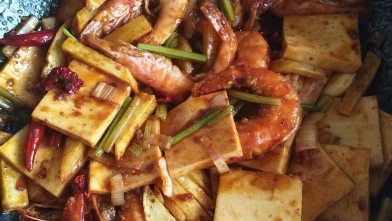 干锅香辣虾,最后放入炸好的虾和土豆条,让底料均匀裹在食材上,放少许鸡精,少许糖,炒匀即可出锅。