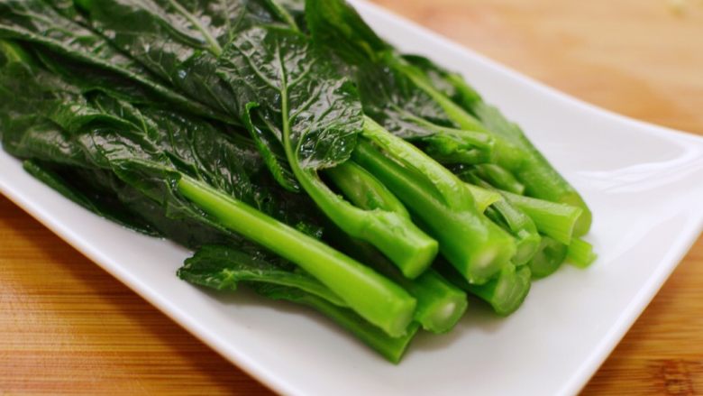 白灼菜心,关火。用筷子夹出来,摆入盘中。