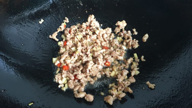肉末茄子煲,倒入腌制好的肉末翻炒至变色;