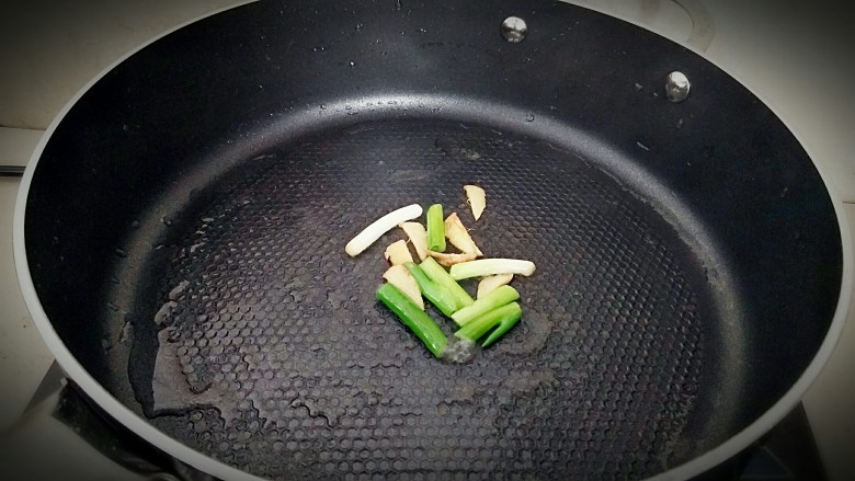 家常版溜肉段,锅中刷一层油,放入葱姜炝锅。