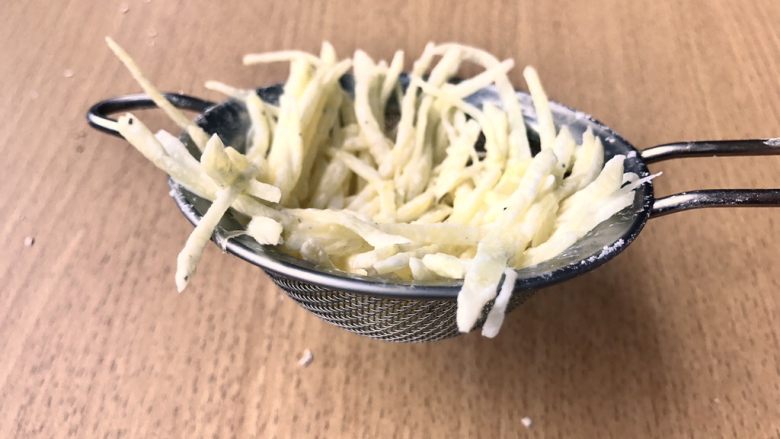 土豆鸟巢和溏心蛋宝宝,用一个漏勺上面铺上土豆丝,尽量贴着边缘铺,形成一个碗状。