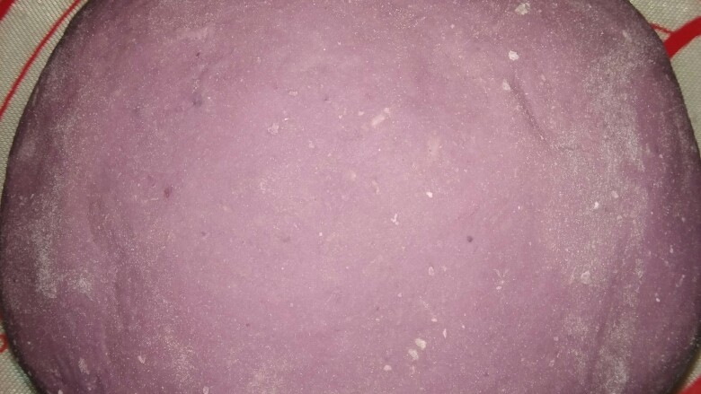 紫薯玫瑰花,紫薯泥中加入150克面粉,揉至表面光滑,用保鲜膜盖起来,等待自然发酵