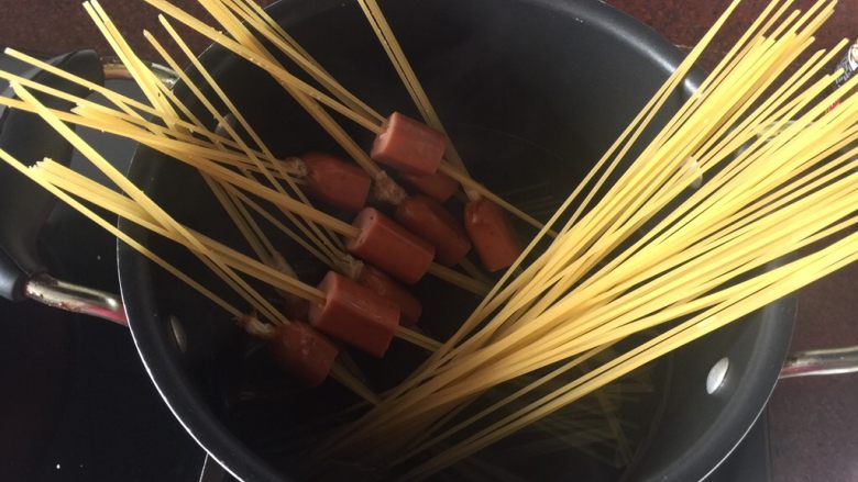 通心肠番茄意面,锅里煮沸水后,放入百味来意面到锅里煮,锅里加入适量盐