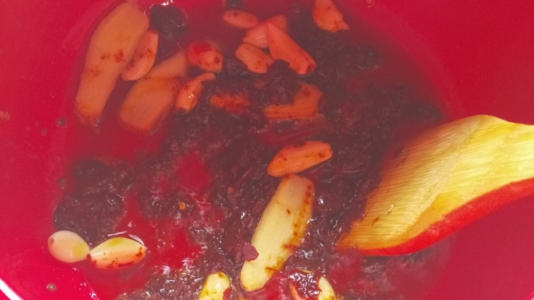 砂锅水煮肉片,待豆瓣酱炒出红油,加入姜片,蒜瓣炒香