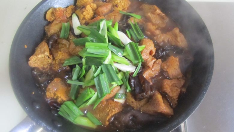 鱼籽烧油豆腐,用锅铲将鱼籽切成适量大小的块, 待汁到浓稠时放入青蒜, 翻炒均匀即可。