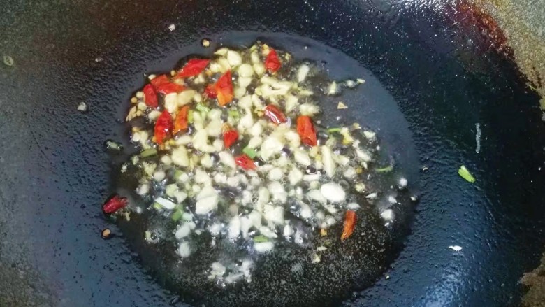 火腿鸡蛋炒面,锅中入适量油,下入蒜末和辣椒煸出香味;