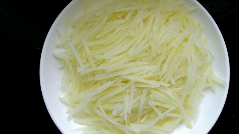 炝拌土豆丝,放入盘中,控去水份