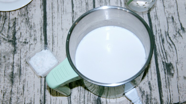 西米蜜豆椰汁糕,把牛奶和椰浆溶液和25克白砂糖放入奶锅,加热至白砂糖融化