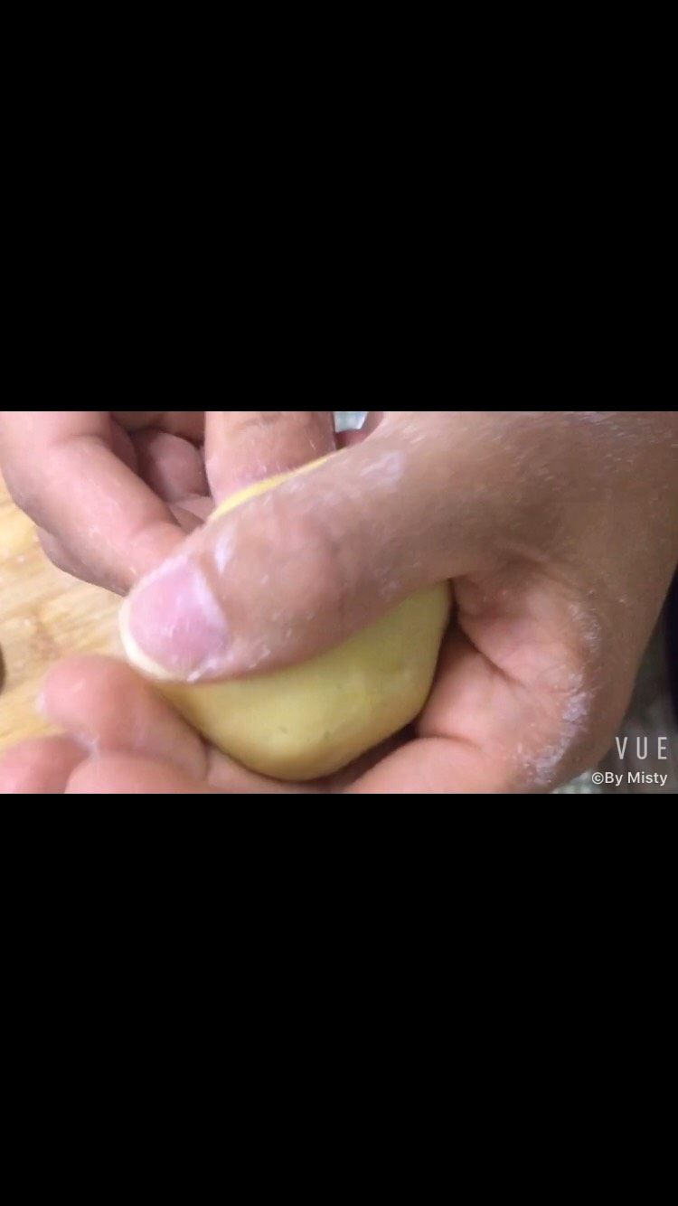 广式月饼,开始包了。先弄点面粉爽爽手。如图，将月饼皮用手掌压瘪，稍微大一点好包。右手将馅往里面顶。注意温柔点。不要破皮了。
