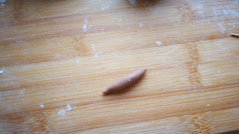 萌萌小羊芹菜猪肉包,将可可色的面团,搓成两头细的纺锤状。