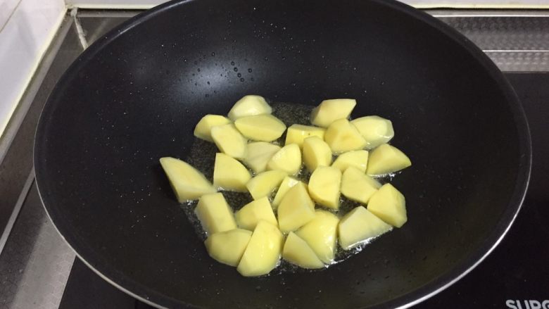 砂锅土豆烧牛肉,炖牛肉的时间用来准备土豆,锅中倒入稍多油,倒入土豆不停翻炒煸炸至表面焦黄