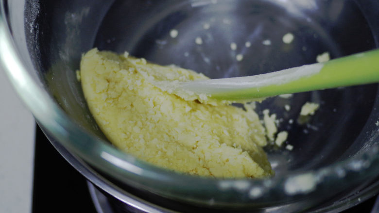 黄桃乳酪派,倒入冷藏好的蛋液,拌匀后用刮刀归置在打蛋盆边上.