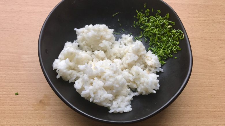 香甜米饭-葱香粢饭糕,将热好的米饭和葱花倒入稍微大一点的碗中。