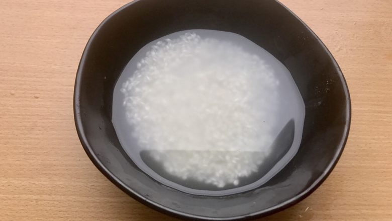 香甜米饭-如何蒸好一碗饭,将水倒掉,再倒入同样一米杯的水,淘第二遍。刚倒入这杯水可以看到虽然依旧不是完全清澈,但是杂质和大部分淀粉已经淘洗掉了。