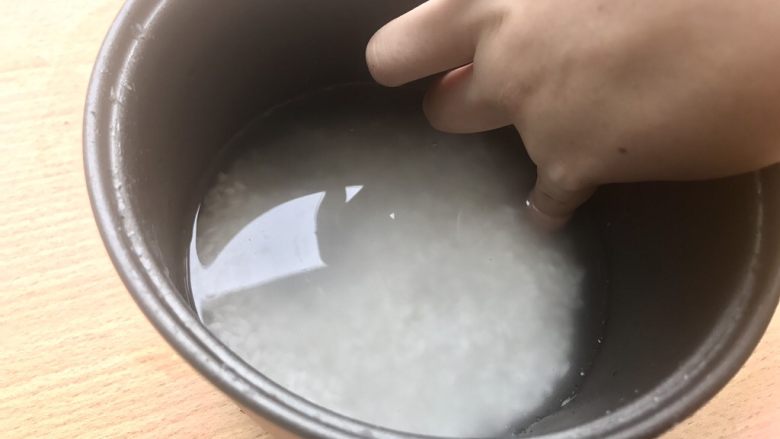 香甜米饭-如何蒸好一碗饭,倒入米饭和腌米水,再加一些矿泉水,使水面高出米面一个食指关节。盖盖开始蒸米饭。如果有砂锅此刻应该大火烧开听到咕噜咕噜沸腾的声音然后中小火20分钟。