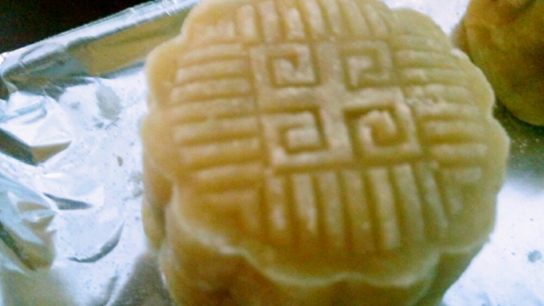 无转化糖浆月饼(附视频),放入预热好的烤箱180℃烘烤5分钟,这叫做定型。然后取出,刷刚刚剩下的蛋液。再放入烤箱150℃烘烤15--20分钟。