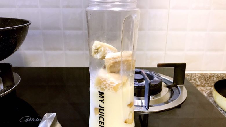 多味早餐香蕉派,牛奶倒入榨汁机瓶中(如果不是像我这样用凉白开冲的奶粉,建议等牛奶放凉些再倒入)