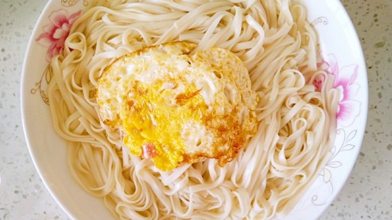 花样面条+快手拌面,鸡蛋煎好后,把它放到面条上面去。