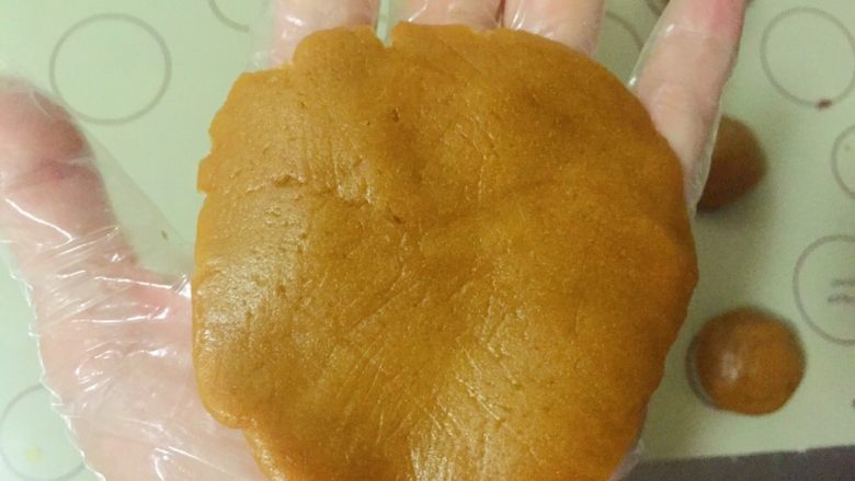 黑糖紫薯广式月饼,取一份面团用手掌按扁,尽量中间厚,边缘薄