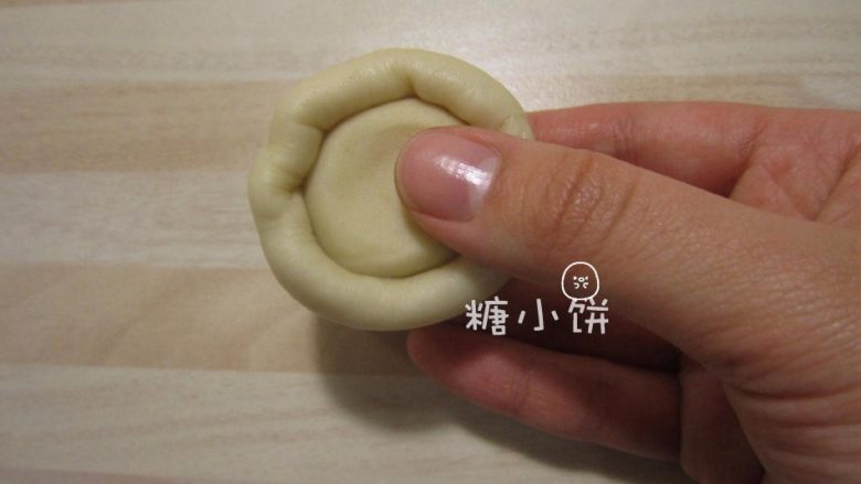 【苏式五仁月饼】,取一个油皮面团压扁,包入一个油酥面团。像包汤圆一样收口,搓圆。依次包好20个
(任何时候都要注意用保鲜膜盖好暂时不操作的面团以免表面风干!)