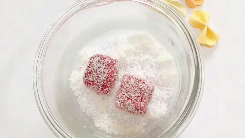 火龙果椰蓉糕,取出凝结的椰蓉糕倒扣脱模切块,放进椰蓉均匀滚几下 摆盘完成