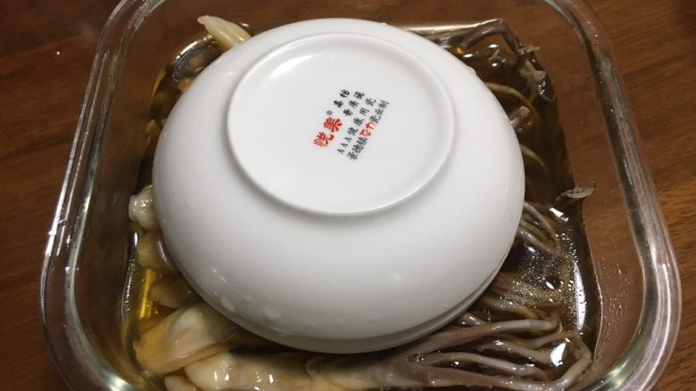 糟卤鸭舌,拿几个干净的小碟子,倒扣在鸭舌上发,碟子超出容器1cm左右高度