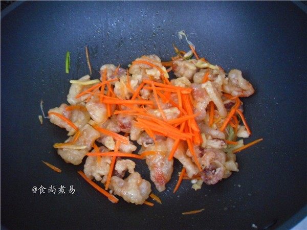 香酥开胃锅包肉,撒上胡萝卜丝,端起锅抛匀食材,即可装盘