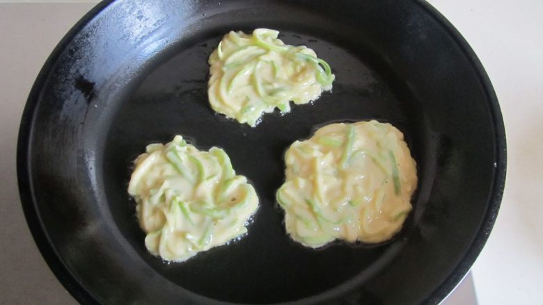 西葫芦鸡蛋饼,烧热锅, 放少许油润下锅底后,倒入适量的面糊入锅中;