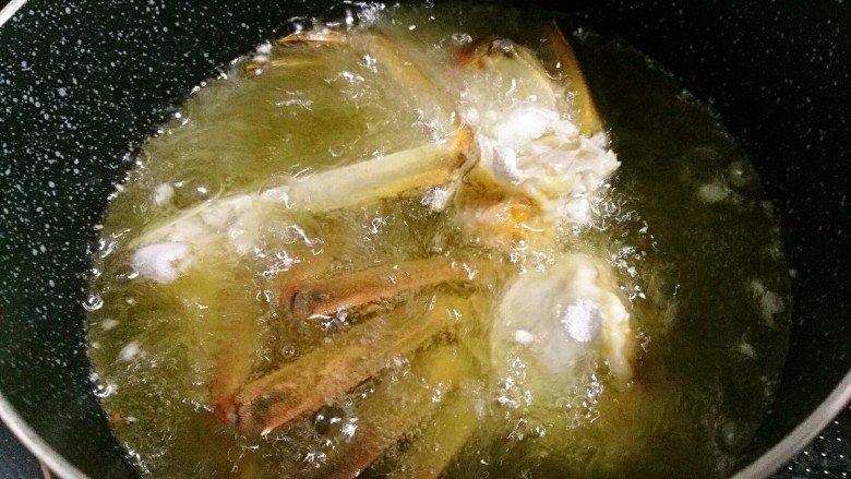 香辣大闸蟹,油七层热时,下蟹炸至变红色后捞出。