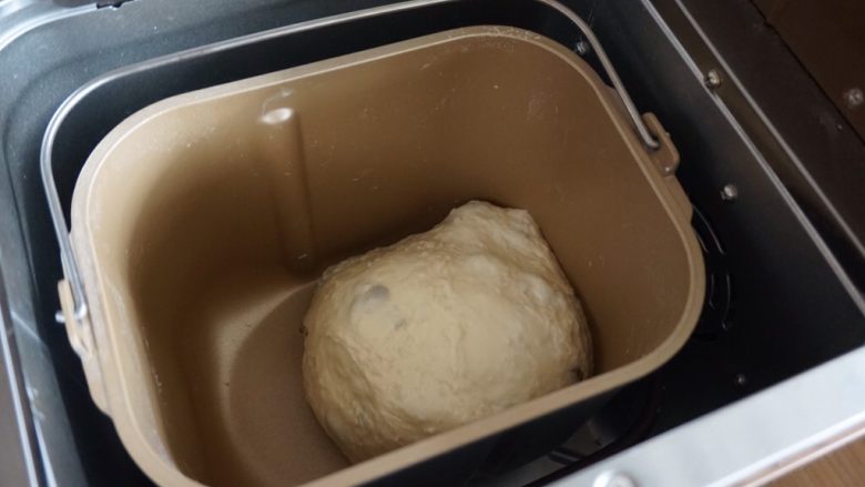 一键式米饭葡萄干面包,室温高的话用冰水,和面的时候可以打开面包机盖,但一定要记得在时间显示到1小时47分前盖上面包机盖。因为这时候,果料盒会自动打开,投放果料。这是和好的面团