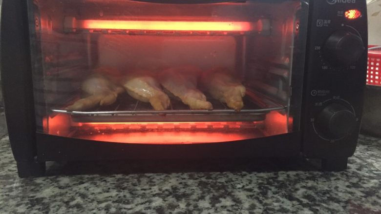 鸡翅包饭,预热后,把鸡翅包饭放入烤箱,用时15-20分钟,温度200°。