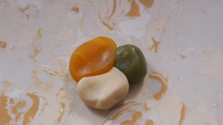 多彩月饼,三种色彩的中间按压紧,然后按压成中间厚四周薄的皮