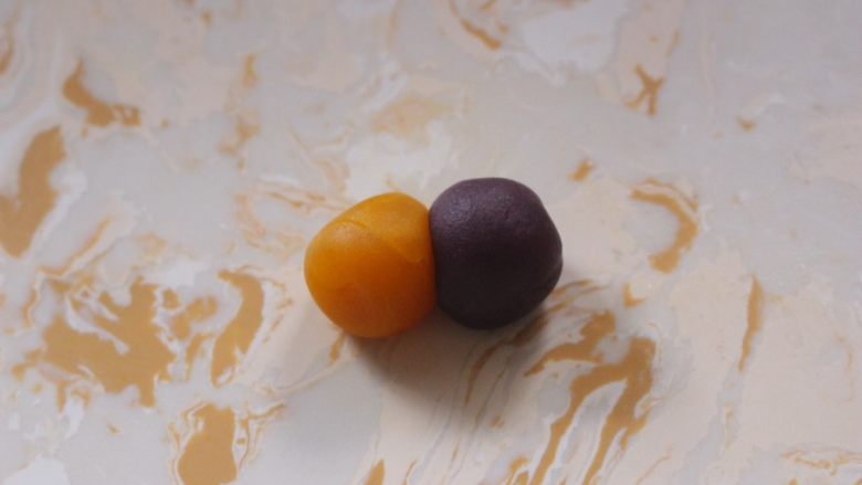 多彩月饼,两种颜色的就在中间按压紧,然后也按压成中间厚四周薄的皮