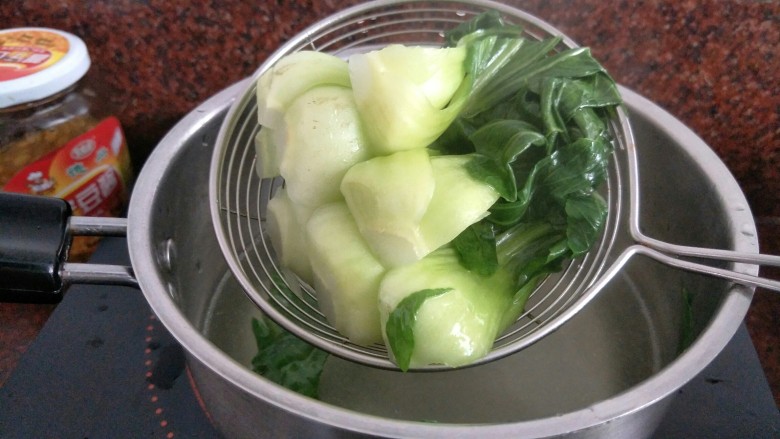 腊肠煲仔饭,煮一锅热水往锅里加一汤勺的植物油,青菜倒入焯一会捞出沥干备用