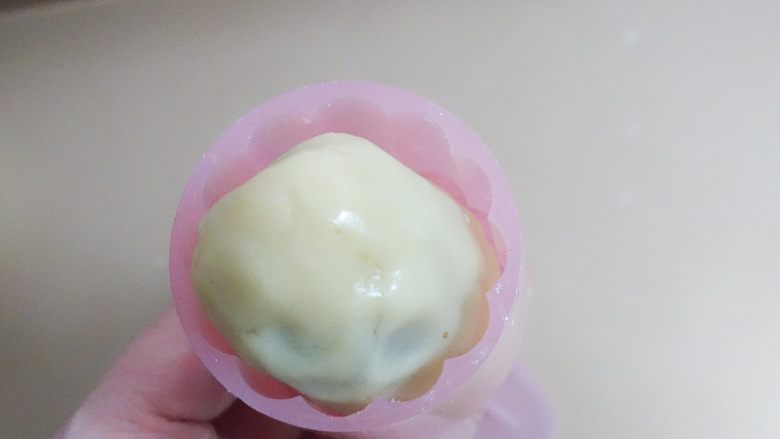 广式莲蓉蛋黄、豆沙蛋黄月饼制作方法,模具抹上面粉,防粘。然后放入模具压造型(最好揉成椭圆形放进模具里,不然太扁会磕到模具边边月饼皮会伤到),月饼的花片最好选择纹理清晰纹路多一点