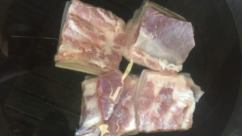 梅菜扣肉,锅中倒水,把洗好的五花肉放进去大火煮开