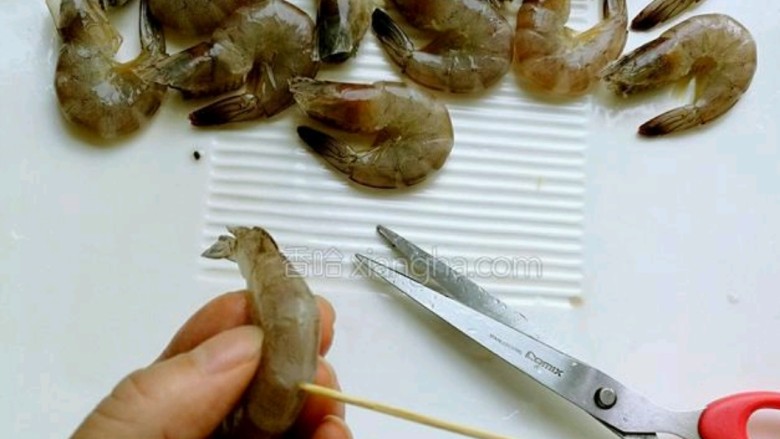 油焖大虾,<a style='color:red;display:inline-block;' href='/shicai/ 293'>基围虾</a>清洗干净后,用剪刀剪去虾须,煎开虾背用牙签除去虾线。
