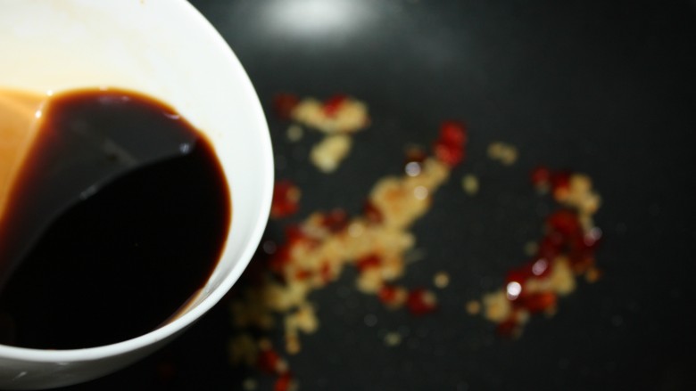 美味下饭宫保豆腐,倒入调好的酱汁。注意边搅拌碗里的酱汁边倒入锅中,否则白糖和淀粉容易沉在碗底。