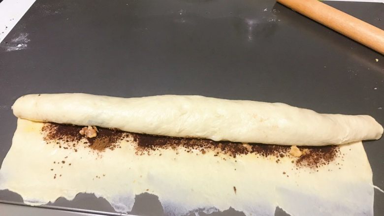 肉桂核桃面包卷,慢慢均勻地捲起來，不要太緊也不要太松，到底邊時，將底邊擀薄（如圖），這樣收尾時就可以自然的貼合起來。