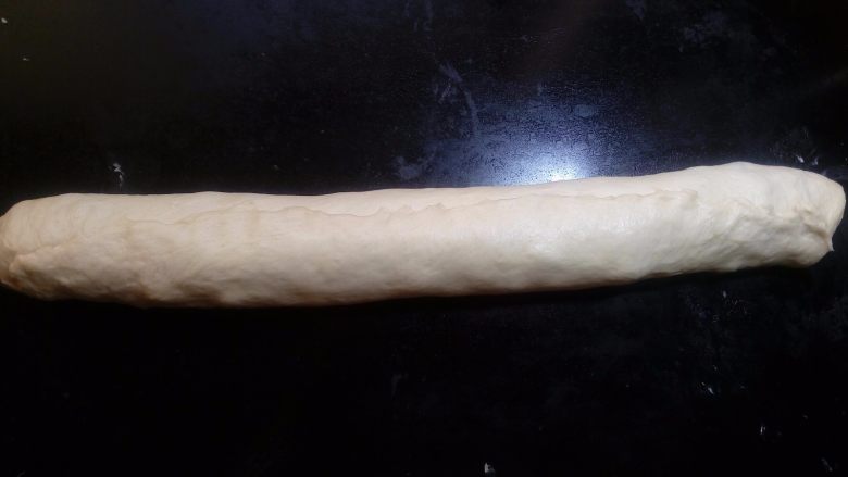 椰蓉花环面包,捏紧最后收口处。接口朝下,稍微压扁一些。