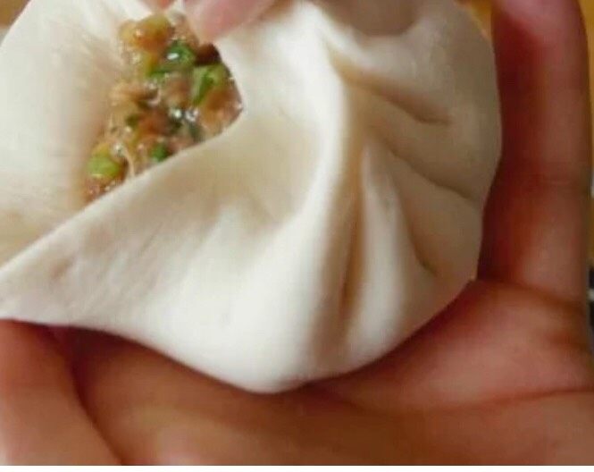生煎包,将肉末放入皮中,捏褶子