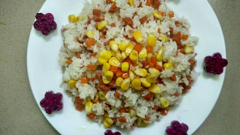 玉米火腿蛋炒饭,装入菜盘,用<a style='color:red;display:inline-block;' href='/shicai/ 608'>火龙果</a>压花装饰即可。