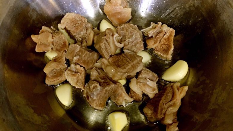咖喱土豆牛腩,倒入牛腩,大火翻炒2分钟后倒入料酒,翻炒均匀。