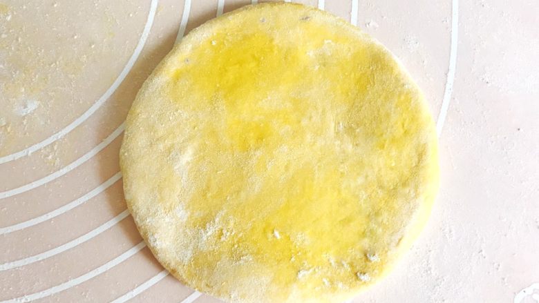 金灿灿的黄金南瓜豆沙馒头,取其中一个面团,用擀面杖擀成中间厚、四周薄的面皮