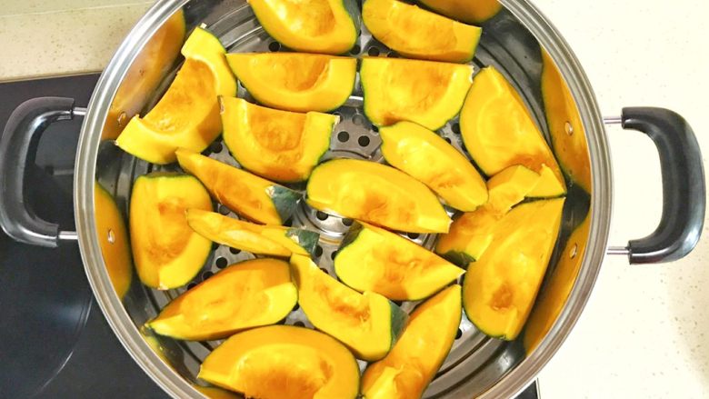 金灿灿的黄金南瓜豆沙馒头,摆放进蒸锅、开火蒸熟,大火烧开后,大约10分钟就可以蒸熟了