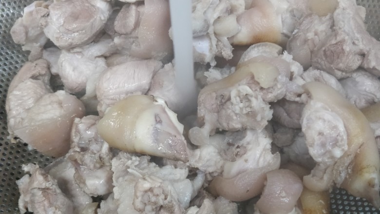 卤水花生焖猪脚,烧一锅开水放4片姜,水开后把猪脚放进去,待水开后再煮一分钟倒出猪脚再用冷水冲洗浮沫,滤干即可。