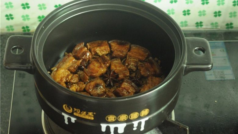 干豆角红烧肉,干豆角切断,铺在砂锅里,将红烧肉块整齐地码在干豆角上面